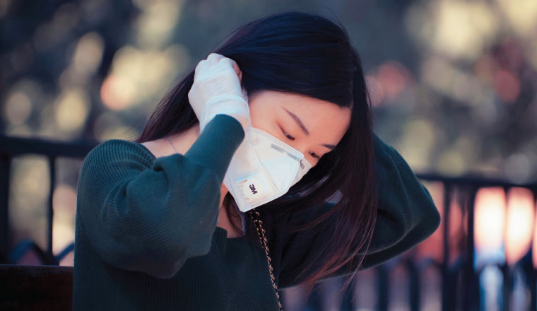 chinese woman covering her face with mask to protect against covid19