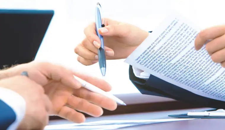 man holding a pen and signing the commercial business registration document